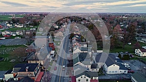 Aerial View of a Small Town and a Steeple as the Sunrises Behind the Camera and Breaks the Horizon on a Spring Sunrise