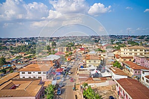 Aerial view of a small village filled with buildings and a road with cars in Kumasi, Ghana