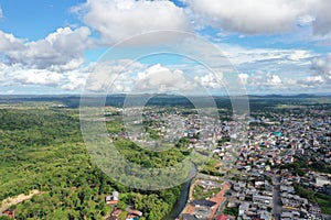 Aerial view of a small village located next to rainforest that starts at the edge of the city