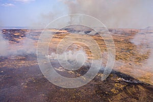 Aerial view of smoke and flames from a large grassfire on moorland in South Wales, UK Llangynidr Moors