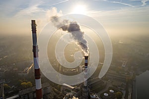 Aerial view of smoking chimneys of CHP plant and smog over the city and builidings in the background