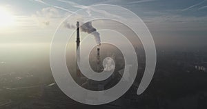 Aerial view of smoking chimneys of CHP plant and smog over the city and builidings in the background - Wroclaw, Poland