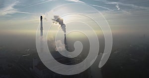 Aerial view of smoking chimneys of CHP plant and smog over the city and builidings in the background - Wroclaw, Poland