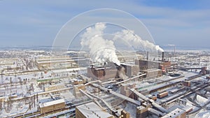 Aerial view of smoking pipes in industrial zone in winter