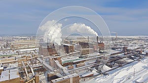 Aerial view of smoking pipes of iron ore mining factory in winter