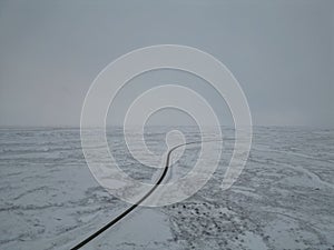 Aerial view of a snow-covered land with a country road. Winter landscape in Iceland.