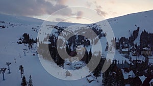 Aerial view of a snow-covered village in the Carpathians in winter at sunset