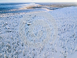Aerial view of snow covered winter forest and road. Beautiful rural landscape in Finland