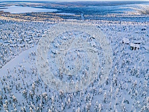 Aerial view of snow covered winter forest and road. Beautiful rural landscape in Finland