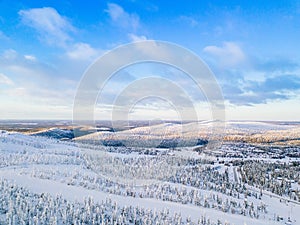 Aerial view of snow covered winter forest and road. Beautiful rural landscape in Finland