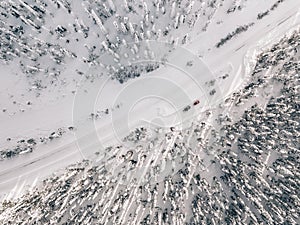 Aerial view of snow covered winter forest and road. Beautiful rural landscape in Finland