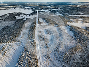 Aerial view of snow winter road and pine woods in Finland