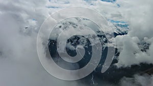 Aerial view of snowcapped mountains in clouds