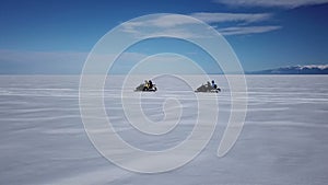 Aerial view snowmobiles ride on the frozen Lake Baikal in winter