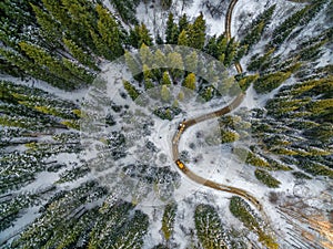 Aerial view of snowy forest with a road. Captured from above with a drone.