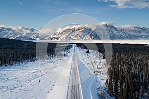 Aerial view of a snowy landscape with mountain ranges and forests in Whitehorse, Yukon, Canada