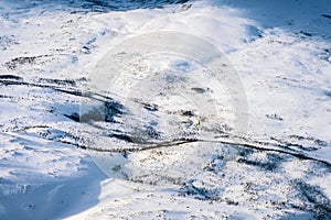 Aerial view of snowy landscape in winter with mountains and forest in Norway