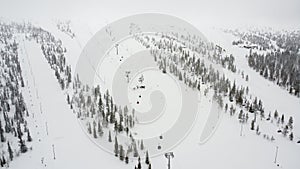 Aerial view of a snowy mountain landscape with a ski lift in Yllas, Finland