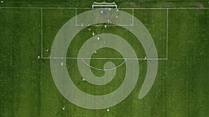 Aerial view of a soccer field in action, with players running, passing, and scoring goals.