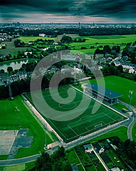 Aerial view of a soccer field with dark clouds looming in the background.