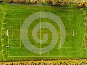 Aerial view, soccer or football field under maintenance, Traktor with feeder and trail all over the pitch