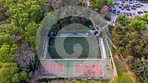 Aerial view of a soccer game in a park stadium next to a tennis court