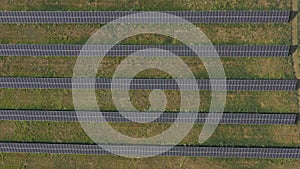 Aerial view of solar panel farm generating electricity. Rows of energy solar panels installed on farmland meadow or