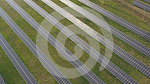 Aerial view of solar panel farm generating electricity. Rows of energy solar panels installed on farmland meadow or