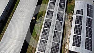 Aerial view of Solar panels installed on a roof of a large industrial building or a warehouse. Top view of solar power station