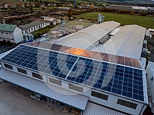 Aerial view of solar panels on a rooftop of factory. Solar energy as renewable energy source in business.
