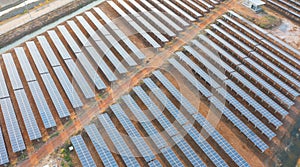 Aerial view of solar panels or solar cells on the roof in farm. Power plant with lake or river, renewable energy source in