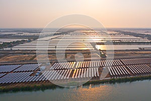 Aerial view of solar panels or solar cells on the roof in farm. Power plant with lake or river, renewable energy source in