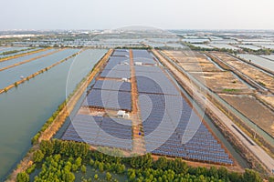 Aerial view of solar panels or solar cells on the roof in farm. Power plant with lake or river, renewable energy source in