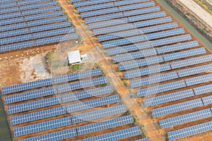 Aerial view of solar panels or solar cells on the roof in farm. Power plant with lake or river, renewable energy source in