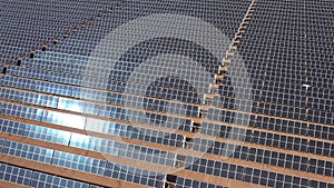 Aerial view of solar panels with sun reflection at the warm heat desert. Green power, ecology, clean alternative energy