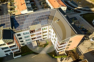 Aerial view of solar photovoltaic panels on a roof top of residential building block for producing clean electric energy.