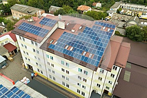 Aerial view of solar power plant with blue photovoltaic panels mounted of apartment building roof