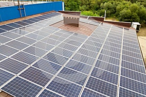 Aerial view of solar power plant with blue photovoltaic panels mounted of industrial building roof