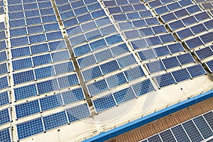 Aerial view of solar power plant with blue photovoltaic panels mounted of industrial building roof