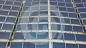 Aerial view of solar power plant with blue photovoltaic panels mounted of industrial building roof.