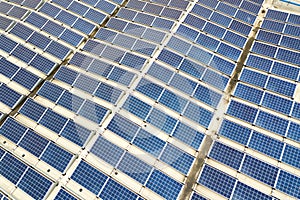 Aerial view of solar power plant with blue photovoltaic panels mounted of industrial building roof