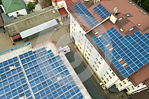 Aerial view of solar power plant with blue photovoltaic panels mounted of industrial building roof