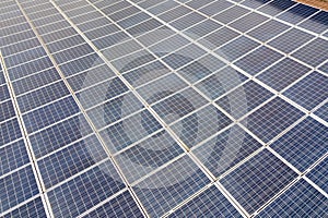 Aerial view of solar power plant with blue photovoltaic panels mounted of industrial building roof