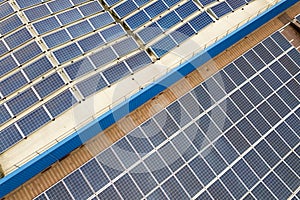 Aerial view of solar power plant with blue photovoltaic panels mounted of industrial building roof