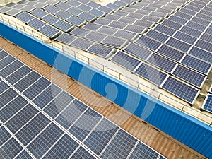 Aerial view of solar power plant with blue photovoltaic panels mounted of industrial building roof