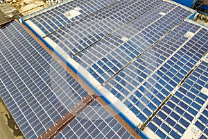 Aerial view of solar power plant with blue photovoltaic panels mounted of industrial building roof