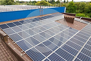 Aerial view of solar power plant with blue photovoltaic panels mounted of industrial building roof