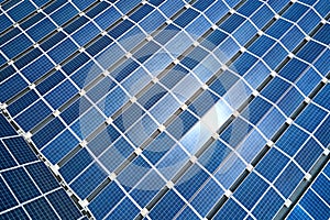 Aerial view of solar power plant with blue photovoltaic panels mounted on industrial building roof for producing green ecological