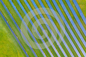 Aerial view of solar power plant on green field. Electric panels for producing clean ecologic energy. Solar cell field. megawatt