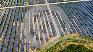 Aerial view of solar power plant on green field. Solar panels system for solar power generation. Green energy for sustainable